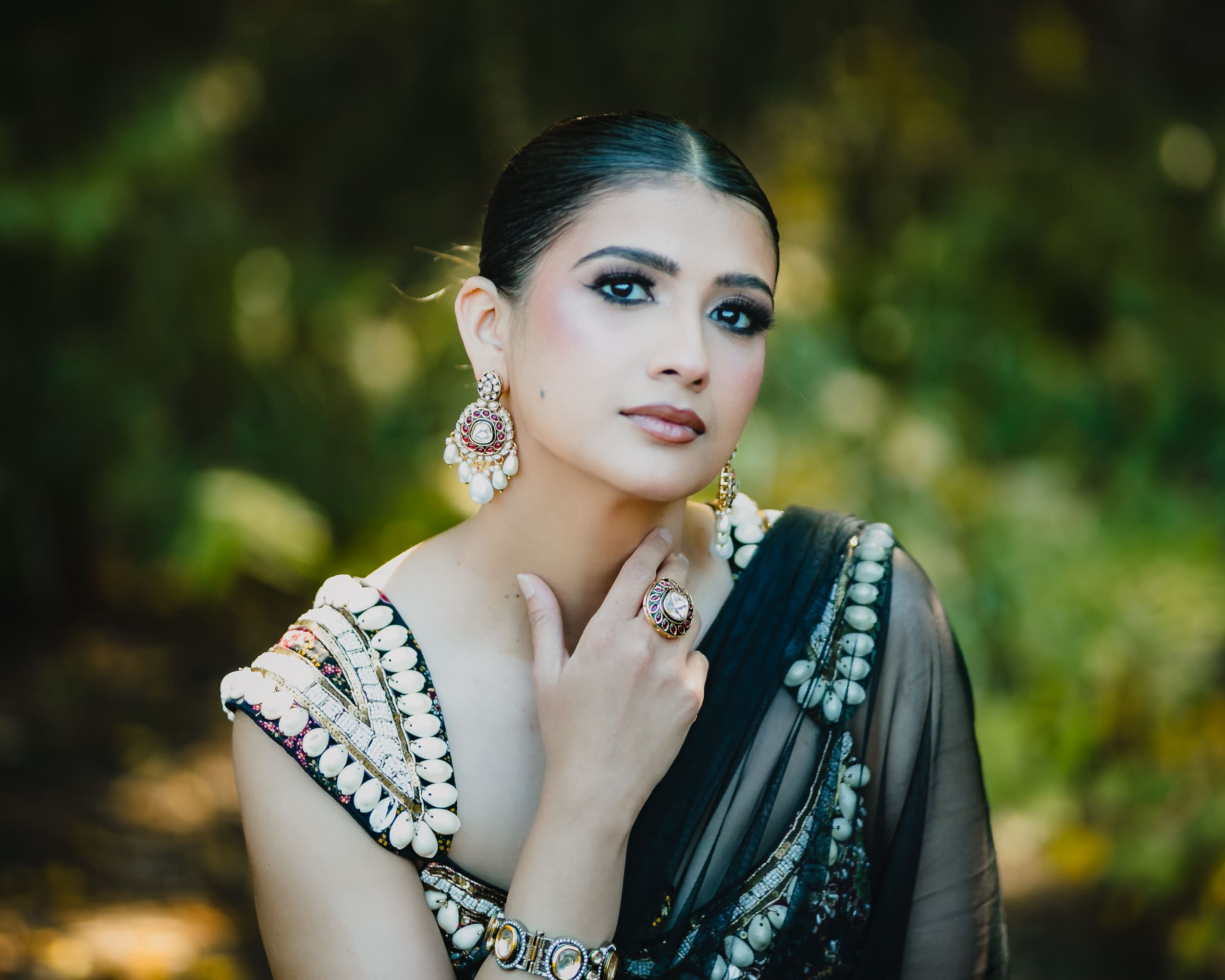 Bridal portrait at Parkwood Estate in Oshawa, Ontario, bride showcasing earrings, ring, and bracelets with soft garden background, cinematic South Asian wedding photography near Toronto and GTA.